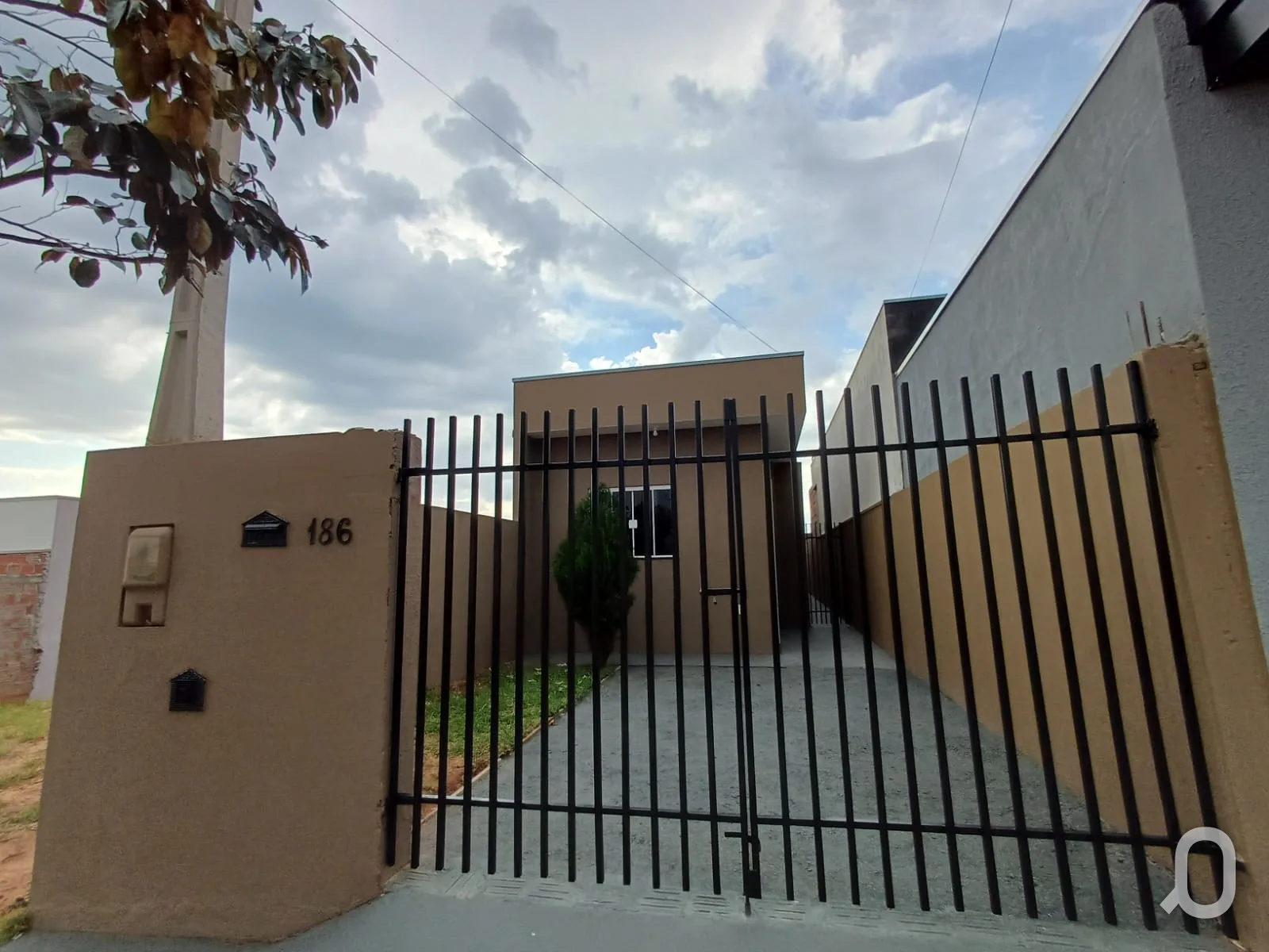 Fachada da casa nova no Residencial Provence, em Pompeia, com muro e portão de grade