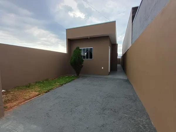 Pátio da frente, em cascalho, com canteiro de grama ao lado