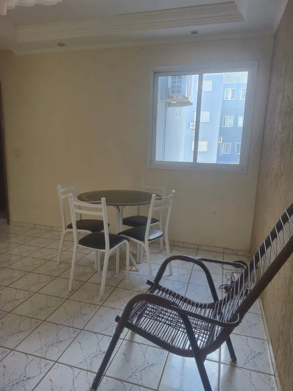 Mesa de jantar redonda com quatro cadeiras e painel espelhado