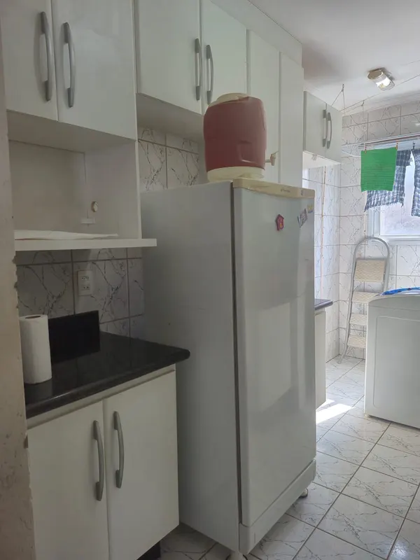 Espaço da cozinha com geladeira branca e armários