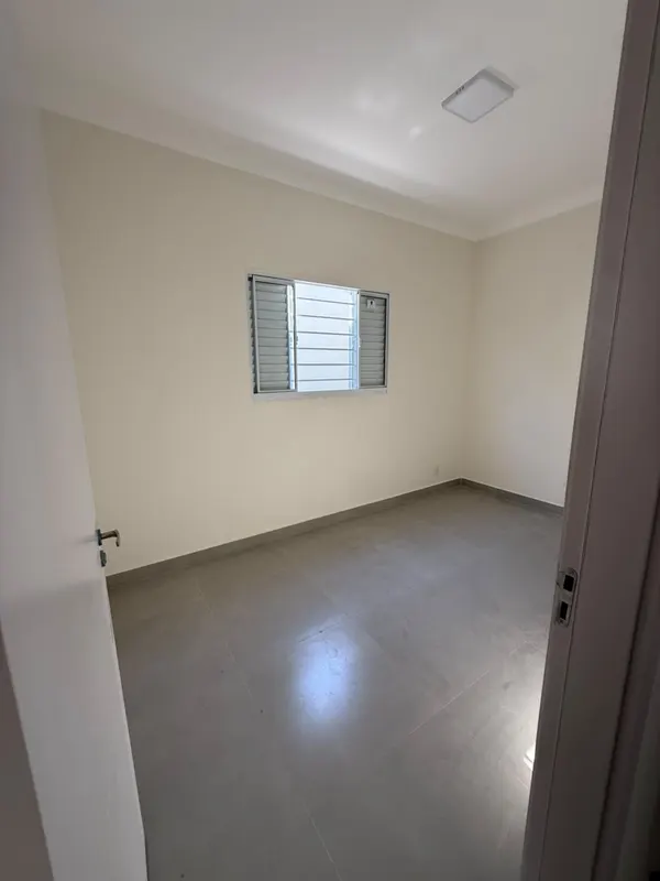 Dormitório com janela ampla e piso em porcelanato claro