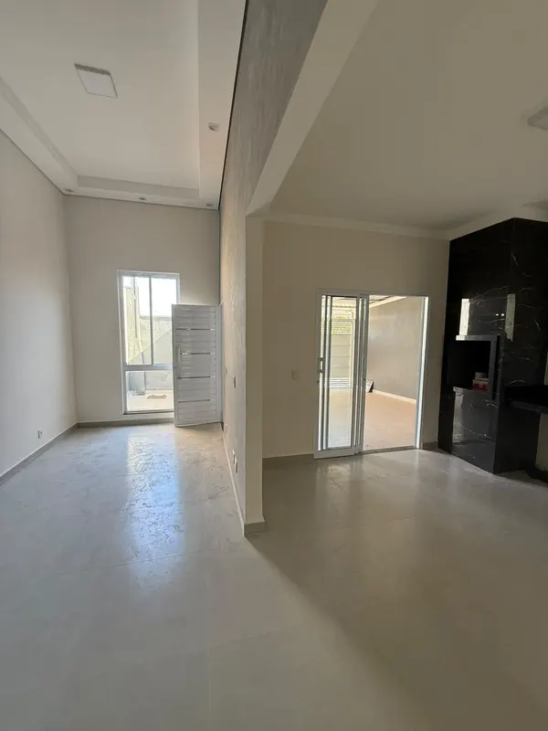 Sala ampla e clara, em porcelanato, aberta para a cozinha