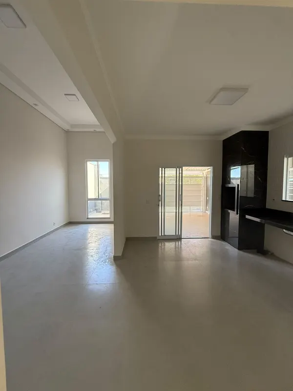 Porta de correr da sala abrindo para a garagem coberta