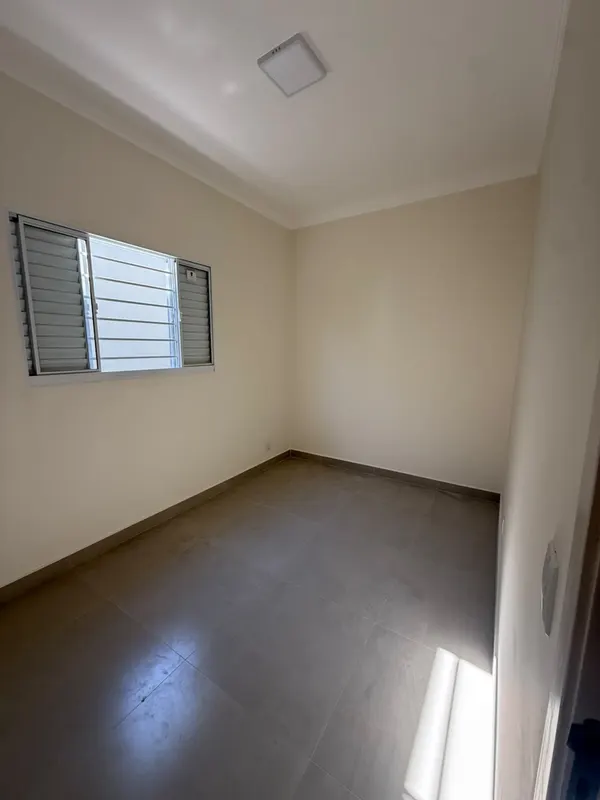 Suíte do casal, com janela e piso em porcelanato